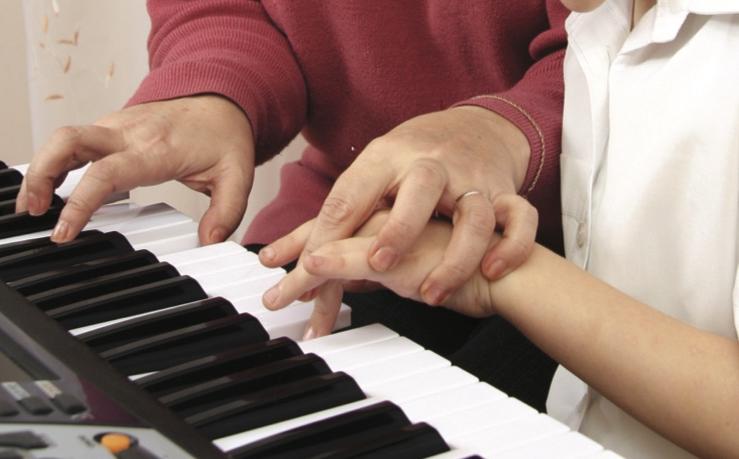 妇女教年轻人弹钢琴