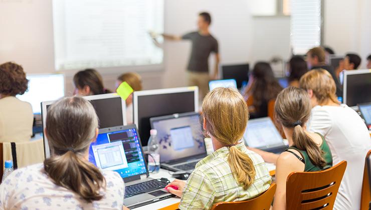 学生们在上课时坐在笔记本电脑前